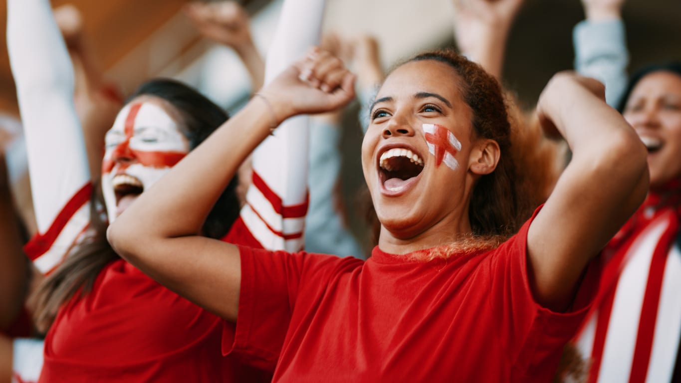 Supportrices au visage peint qui crient leur joie dans les tribunes