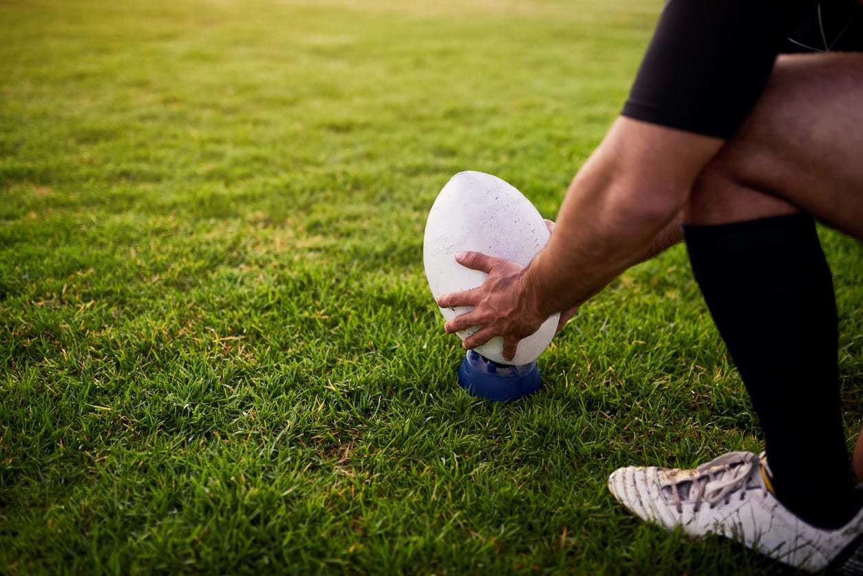 Joueur de rugby posant le ballon sur la pelouse avant de tenter une pénalité