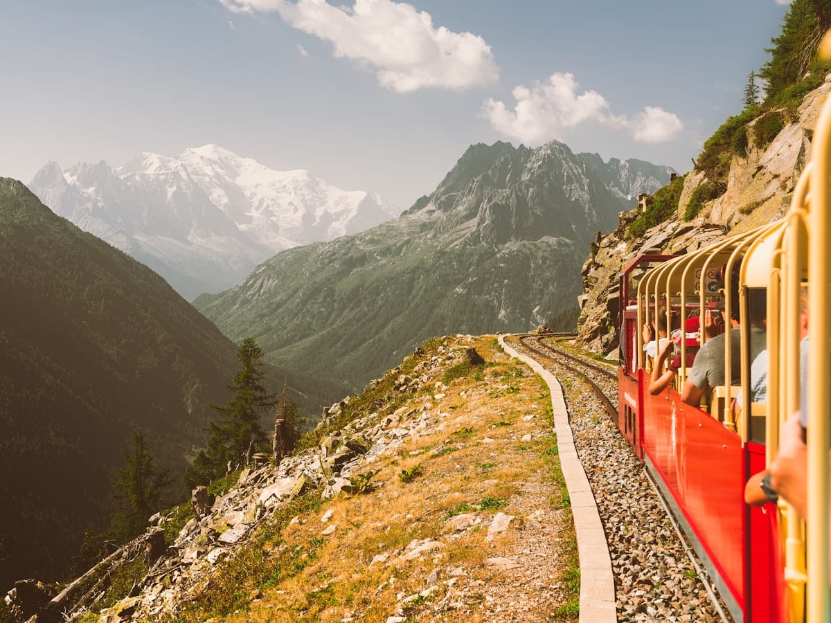 Red train traveling on a mountain track
