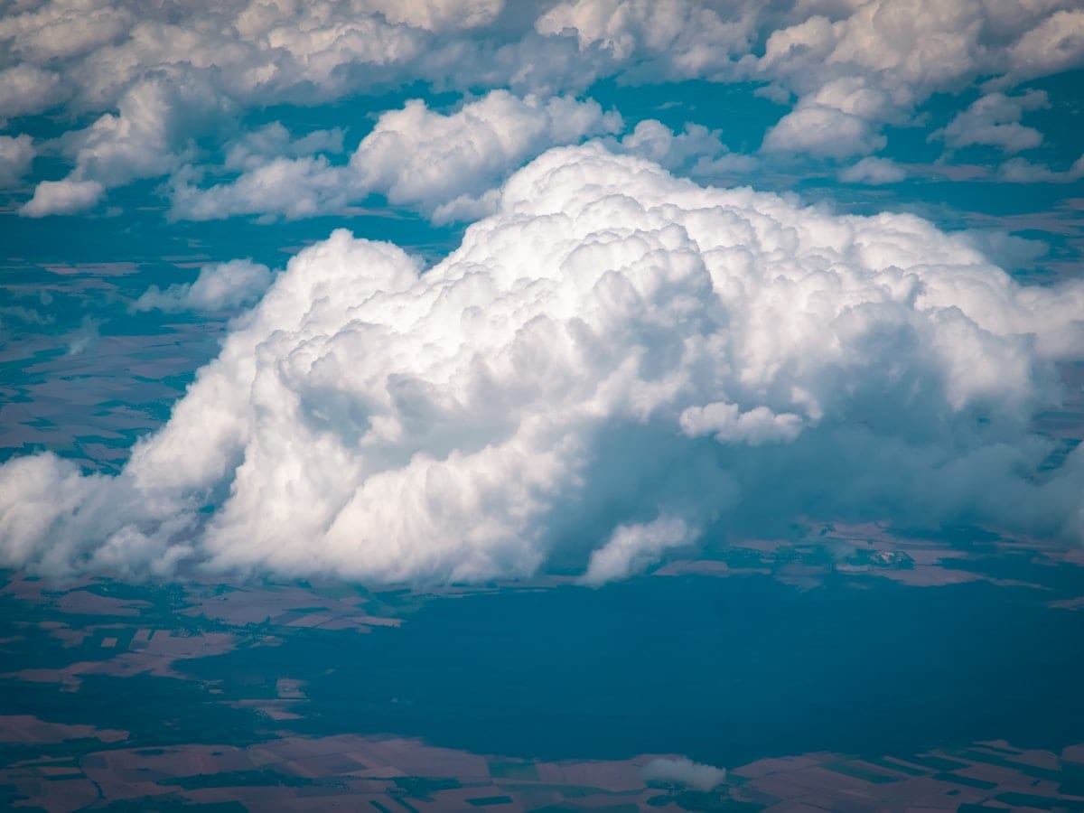 a large cloud is in the sky above the land
