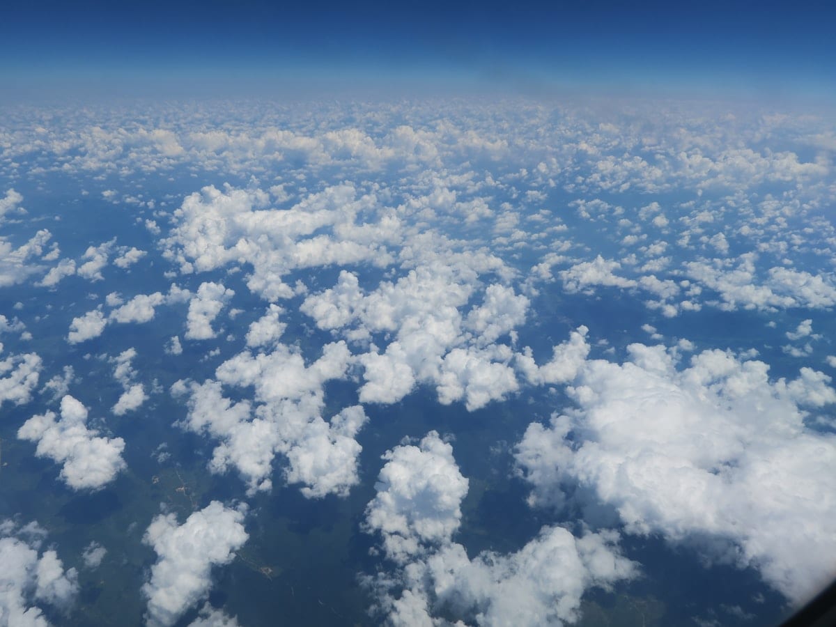 Aerial view of scattered clouds beneath a clear blue sky.