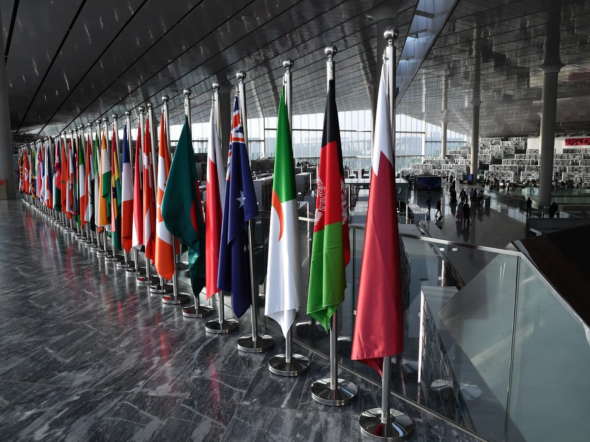 Row of national flags displayed indoors