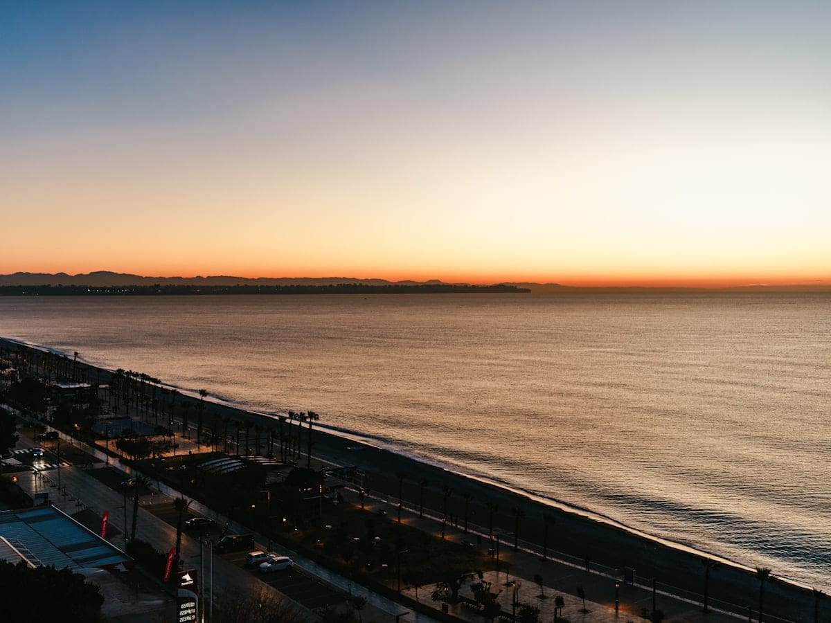 a view of a beach at sunset from a high point of view