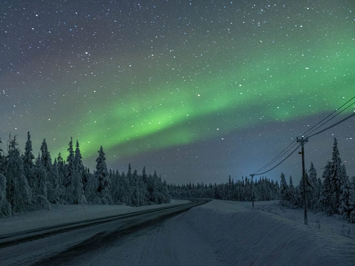 green aurora lights over the road