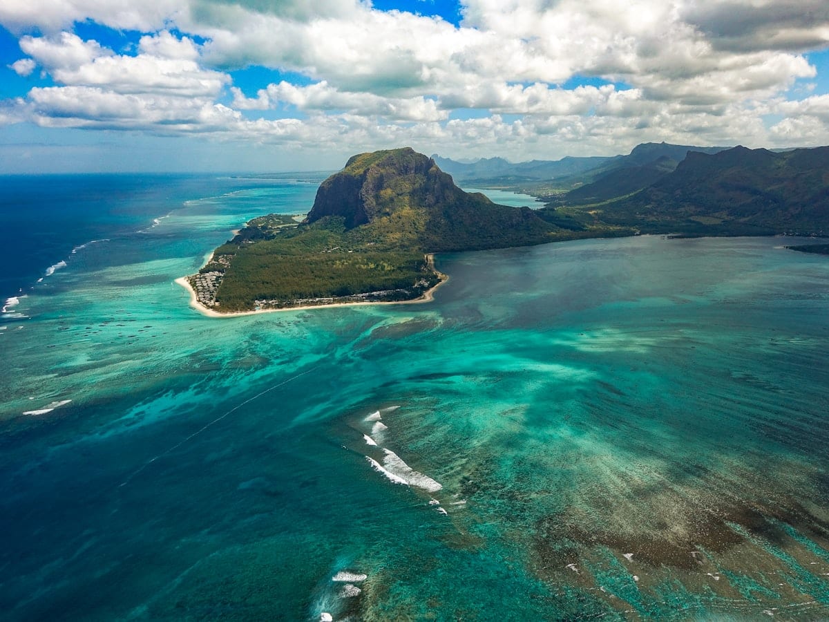aerial photography of sea near mountain at daytime