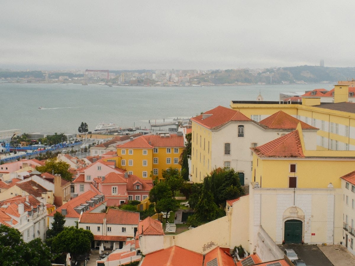 Cityscape overlooking a wide river with buildings.