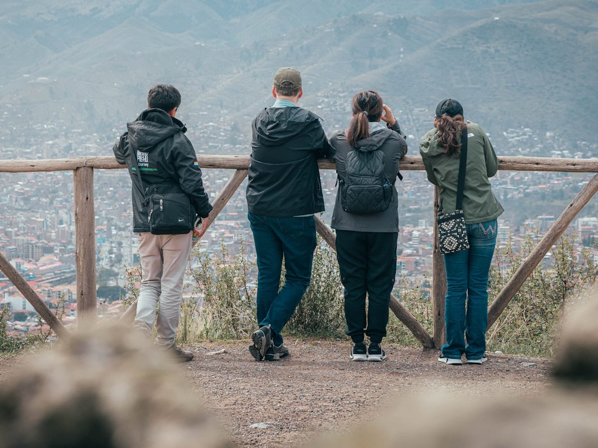 Four people looking out over a city from a viewpoint.