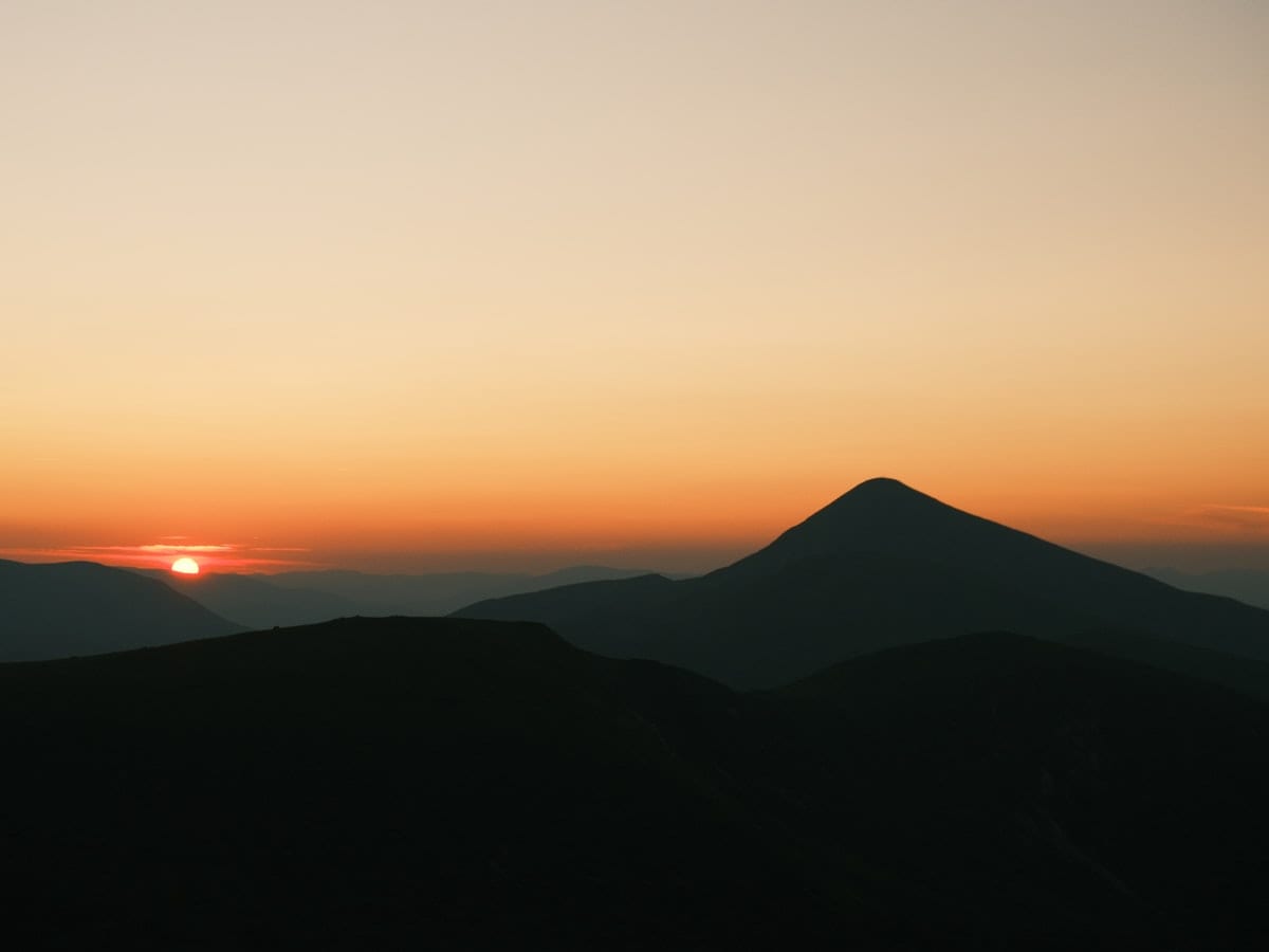 Sunrise over silhouetted mountain peaks