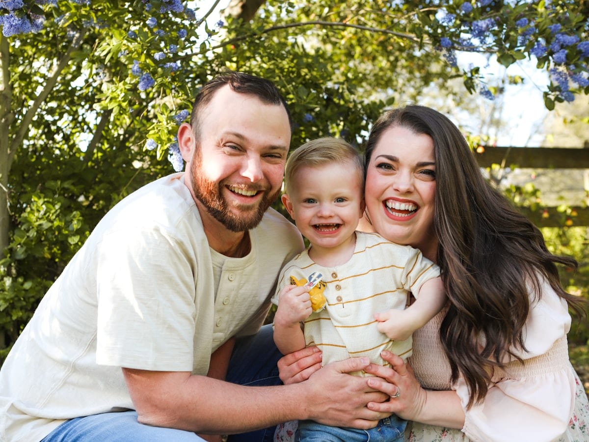 a man and a woman are holding a baby