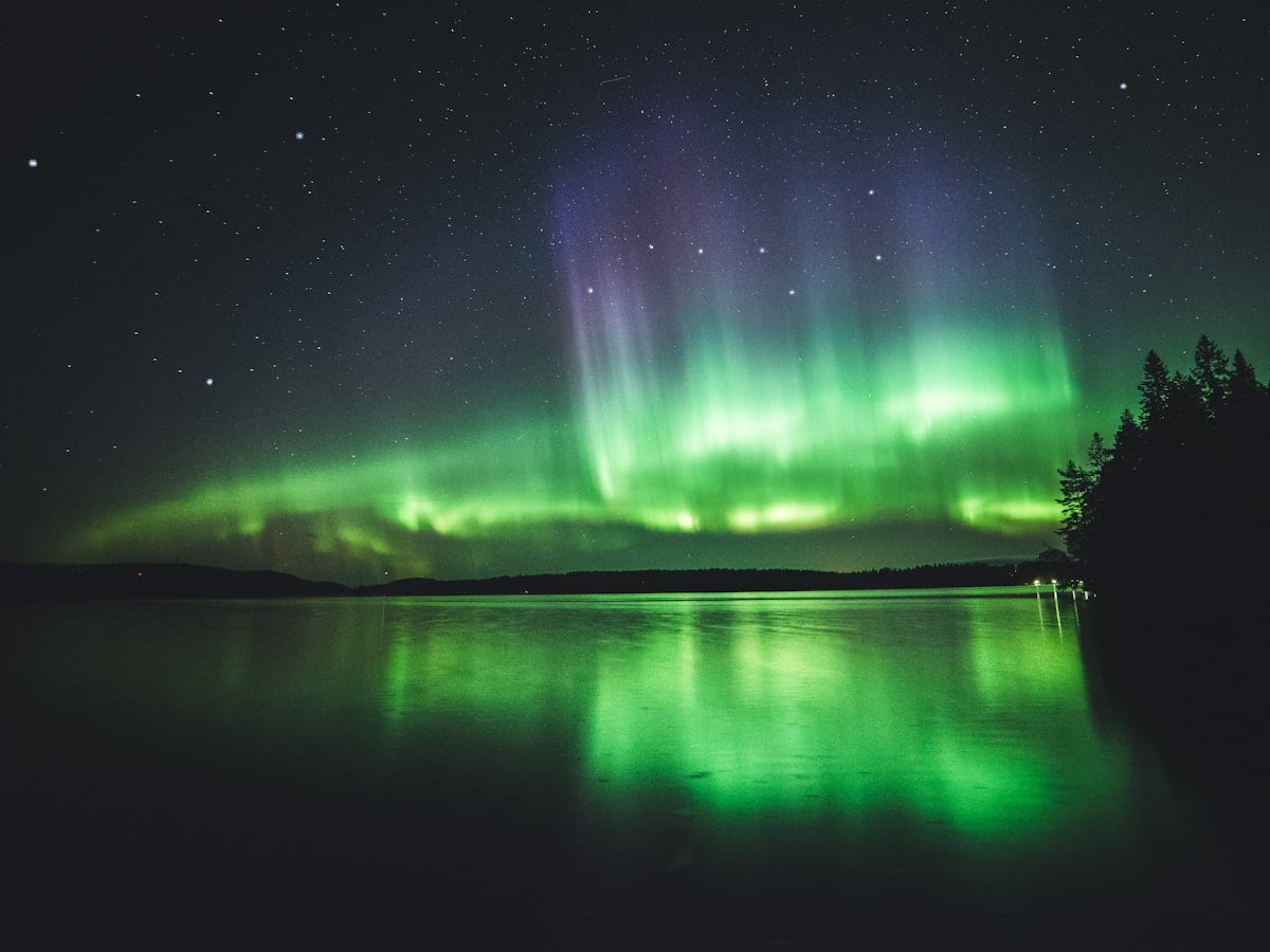 Aurore boréale au-dessus d'une forêt enneigée de Laponie finlandaise — Voyage en Finlande avec CTA Voyages